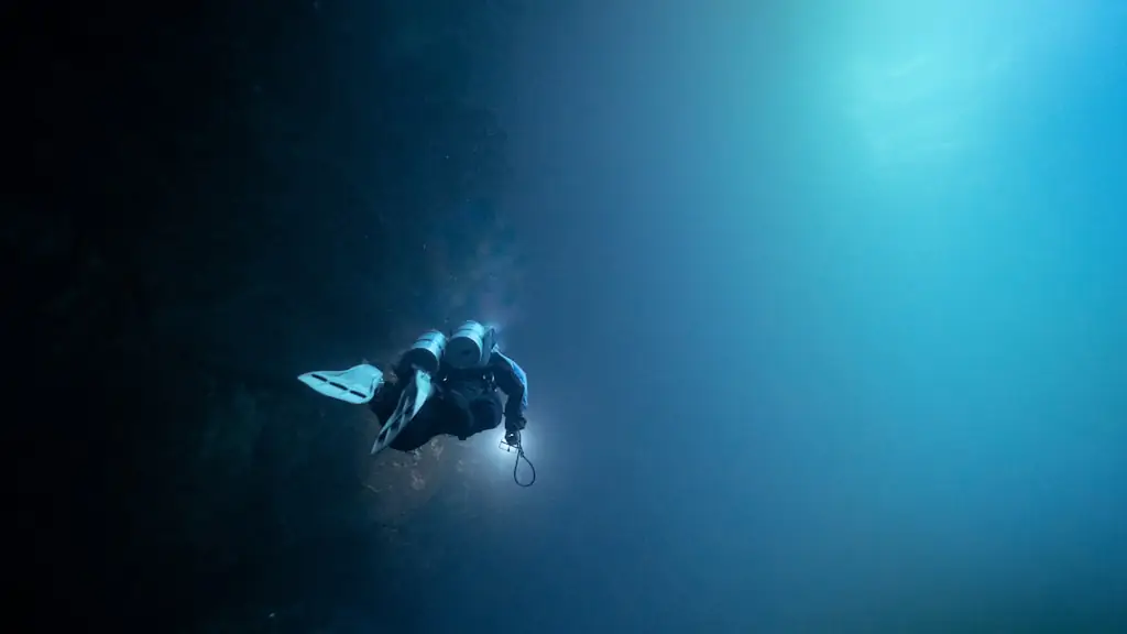 A single scuba diver silhouetted against deep blue open water